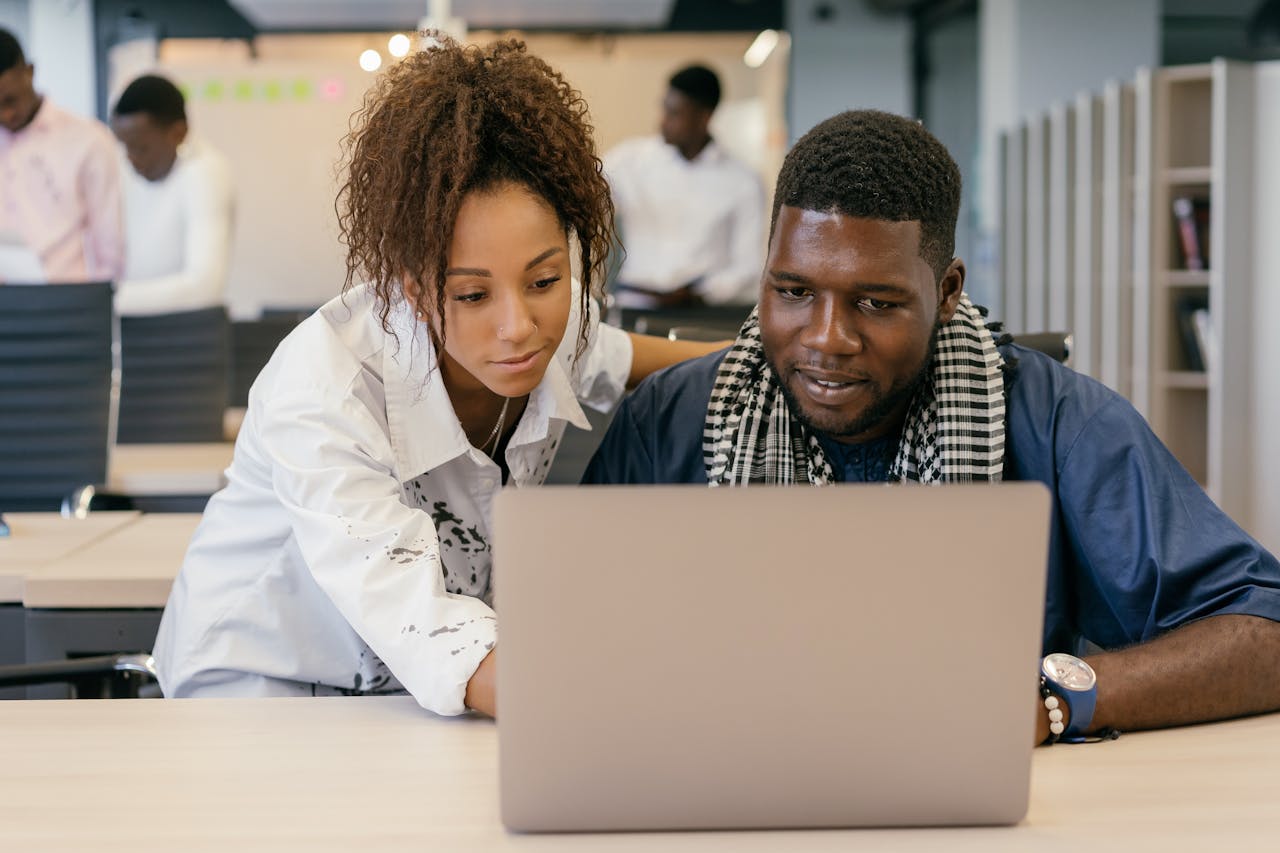 Man and Woman Looking at a Laptop